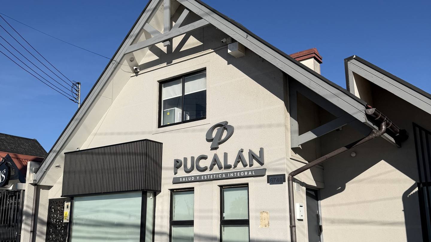 Fachada lateral del edificio de Clínica Pucalán, con el logo instalado sobre el muro blanco y el acceso principal